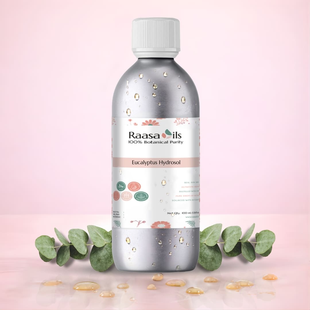 Bottle of Raasa Oils Eucalyptus Hydrosol on a pink background with eucalyptus leaves.