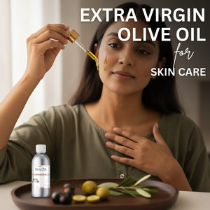 Woman applying olive oil to her face with a dropper, surrounded by olives and a bottle of olive oil.