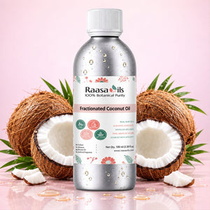 Bottle of Raasa Oils Fractionated Coconut Oil with coconuts on a pink background