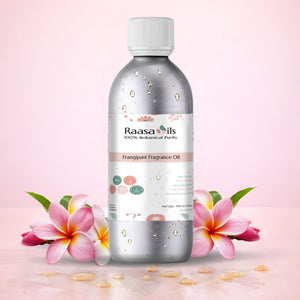 Bottle of Raasa Oils Frangipani Fragrance Oil with flowers on a pink background