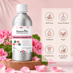A bottle of Raasa Oils Geranium Essential Oil stands on a wooden pedestal surrounded by pink geranium flowers and petals, with a pink informational panel showing product benefits beside it.