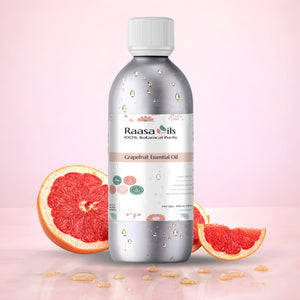 Raasa Oils Grapefruit Essential Oil bottle with grapefruit slices on a pink background