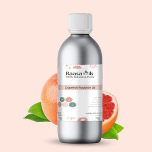 Bottle of Raasa Oils Grapefruit Fragrance Oil with grapefruit and leaves on a light pink background