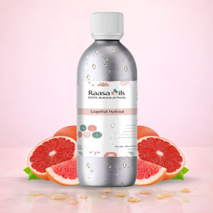 Bottle of Raasa Oils Grapefruit Hydrosol with grapefruit slices on a pink background