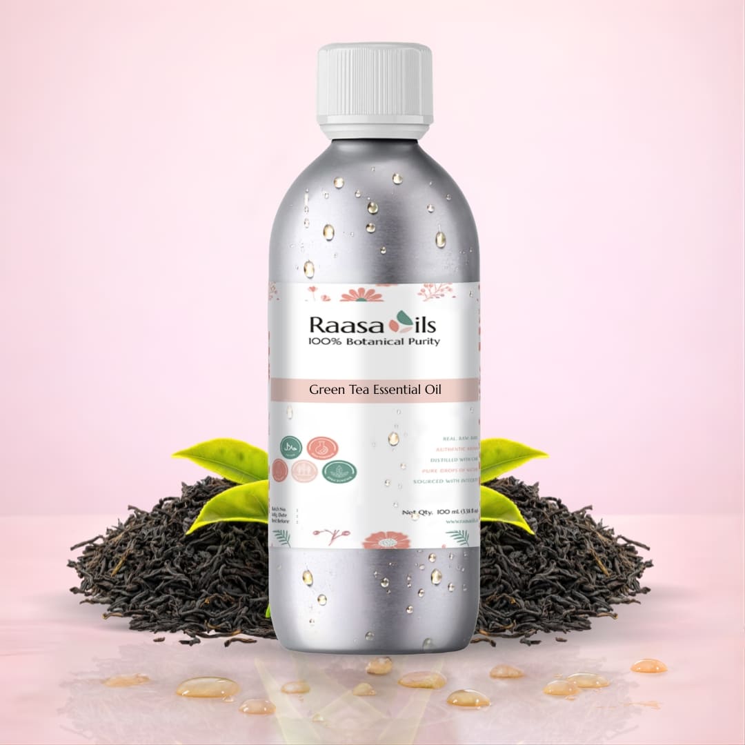 Raasa Oils Green Tea Essential Oil bottle with tea leaves on a pink background
