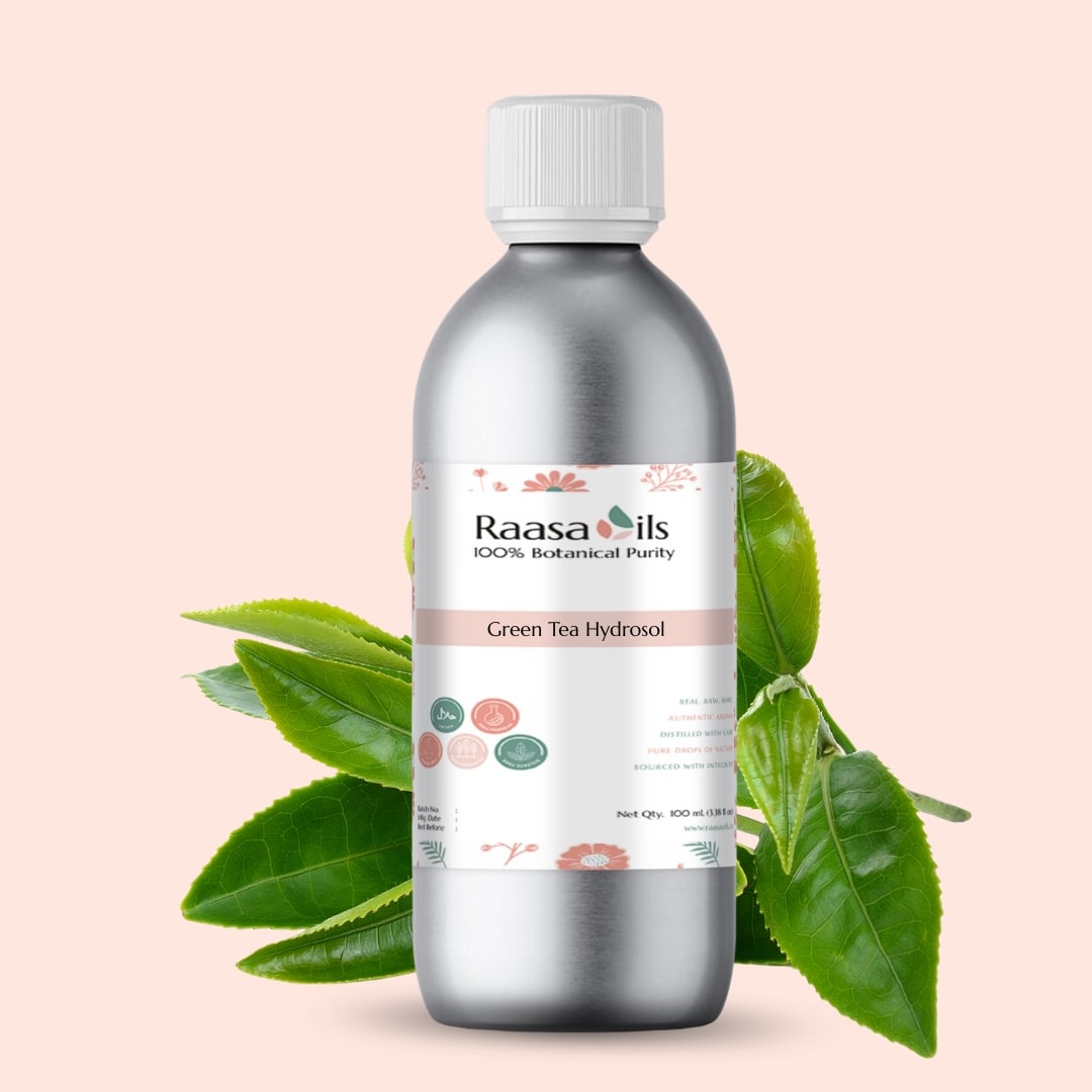 Bottle of Raasa Oils Green Tea Hydrosol with green tea leaves on a beige background