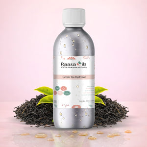 Bottle of Raasa Oils Green Tea Hydrosol with green tea leaves on a pink background