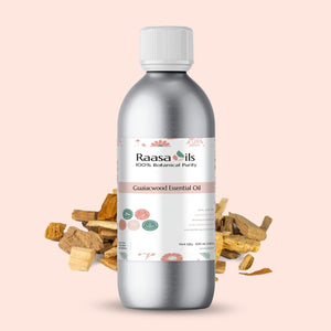 Bottle of Raasa Oils Gualacwood Essential Oil with dried gaulacwood pieces on a beige background