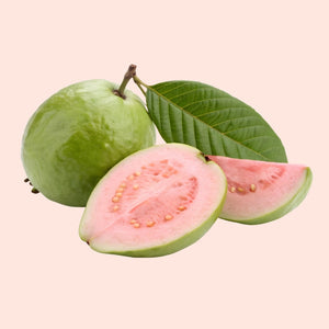 Whole and sliced guava on a light pink background