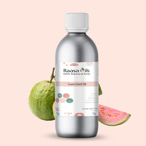 Bottle of Raasa Oils Guava Seed Oil with guava fruit on a pink background