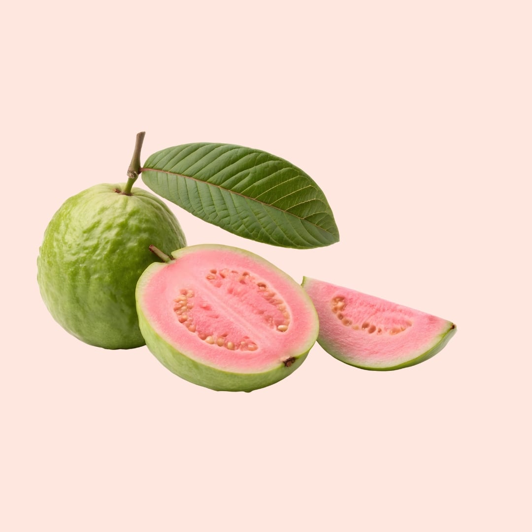 Guava fruit with a slice and leaves on a light pink background