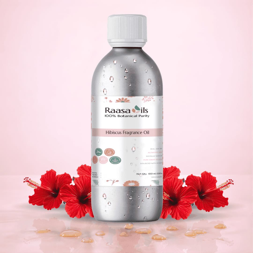 Bottle of Raasa Oils Hibiscus Fragrance Oil with red flowers on a pink background