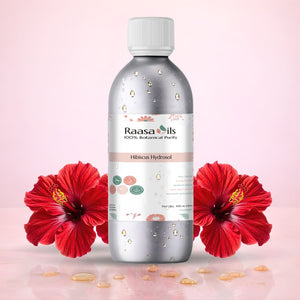 Bottle of Raasa Oils Hibiucus Hydrosol with a red flower on a beige background