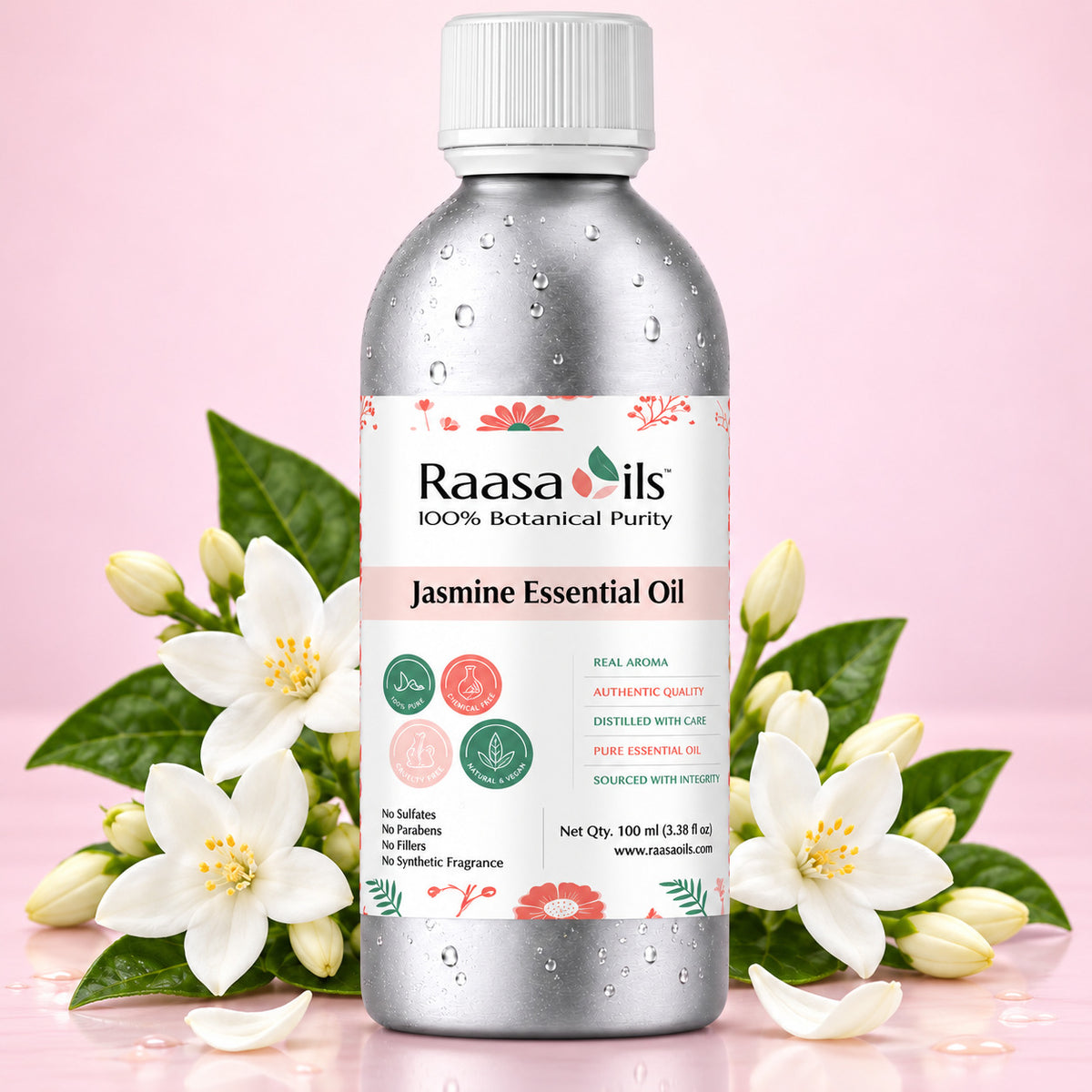 A bottle of Raasa Oils Jasmine Essential Oil centered on a soft pink background, surrounded by white jasmine flowers and green leaves. The bottle is metallic silver with a white cap and a white label featuring pink and green accents.