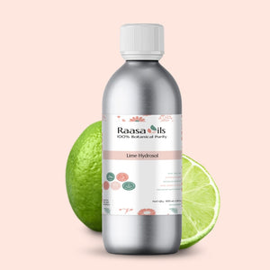 Bottle of Raasa Oils Lime Hydrosol with lime fruit on a light pink background
