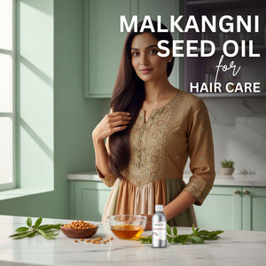 Woman with long hair standing in a kitchen with malkangni seed oil and leaves on the counter.