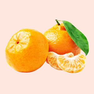 Oranges with a slice and a leaf on a light pink background