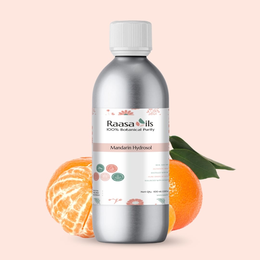 Bottle of Raasa Oils Mandarin Hydrosol with mandarin fruit and leaves on a light pink background