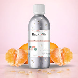 Bottle of Raasa Oils Mandarin Hydrosol with mandarin oranges on a pink background