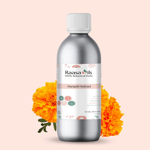 Bottle of Raasa Oils Marigold Hydrosol with marigold flowers on a light pink background