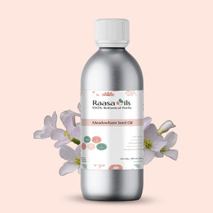 Bottle of Raasa Oils Meadowfoam Seed Oil with flowers on a light pink background