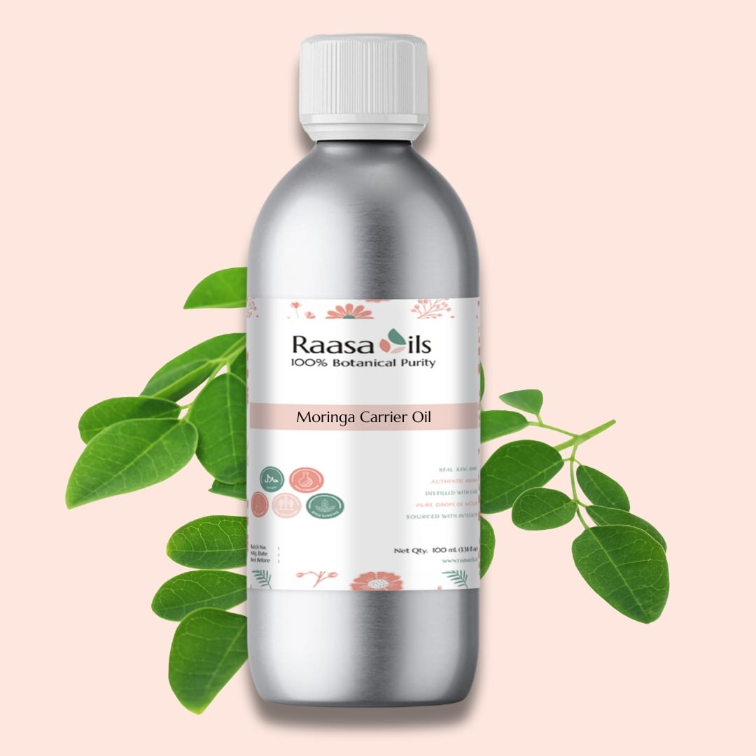 Bottle of Raasa Oils Moringa Carrier Oil with green leaves on a pink background
