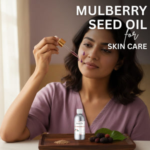 Woman applying mulberry seed oil to her face with a dropper, surrounded by mulberries and a bottle of the oil.