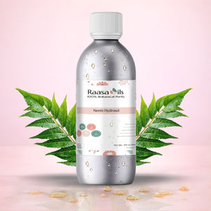 Bottle of Raasa Oils Neem Hydrosol with green leaves on a pink background