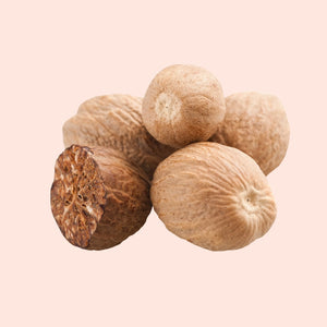 Group of nutmeg fruits on a beige background