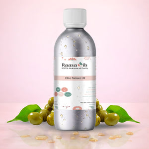 Bottle of Raasa Oils Olive Pomace Oil with olive fruits and leaves on a pink background