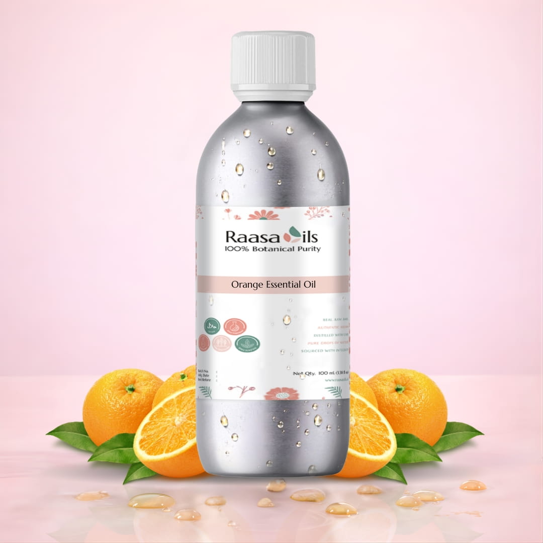 Bottle of Raasa Oils Orange Essential Oil with oranges and leaves on a pink background