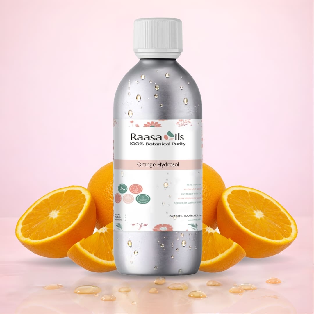 Bottle of Raasa Oils Orange Hydrosol with oranges on a pink background