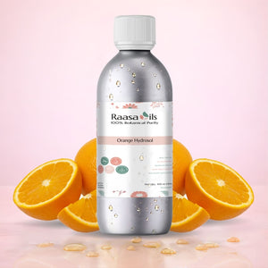 Bottle of Raasa Oils Orange Hydrosol with oranges on a pink background