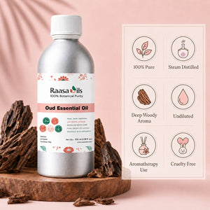 A bottle of Raasa Oils Oud Essential Oil stands on a wooden pedestal against a soft pink background, with decorative wood pieces around the base and a feature infographic on the right showing '100% Pure', 'Steam Distilled', 'Deep Woody Aroma', 'Undiluted', 'Aromatherapy Use', and 'Cruelty Free'.