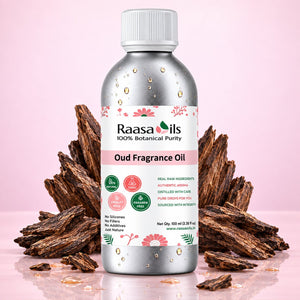A bottle of Raasa Oils 100% Botanical Purity Oud Fragrance Oil, presented on a reflective pink surface with dried oud wood pieces in the background.