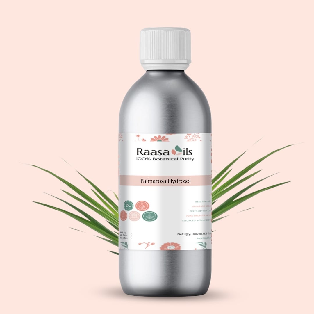 Bottle of Raasa Oils Palmarosa Hydrosol on a light pink background with palm leaves.