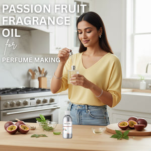 Woman holding a bottle of passion fruit fragrance oil in a kitchen setting with passion fruits on the counter.