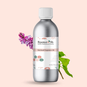 Bottle of Raasa Oils Patchouli Fragrance Oil with a pink flower and green leaf on a light pink background