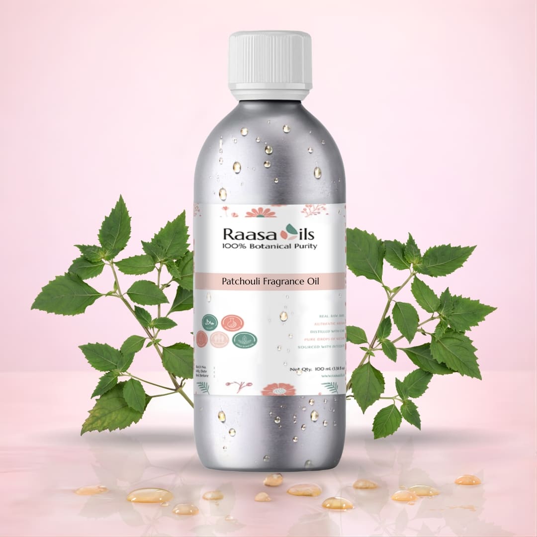 Bottle of Raasa Oils Patchouli Fragrance Oil with green leaves on a pink background