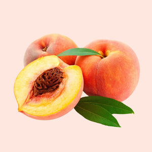 Peaches with one cut open on a light pink background