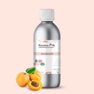 Bottle of Raasa Oils Peach Kernel Oil with peach fruits on a light pink background