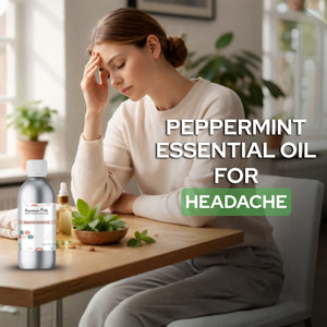 Woman with a headache sitting at a table with peppermint essential oil and plants.