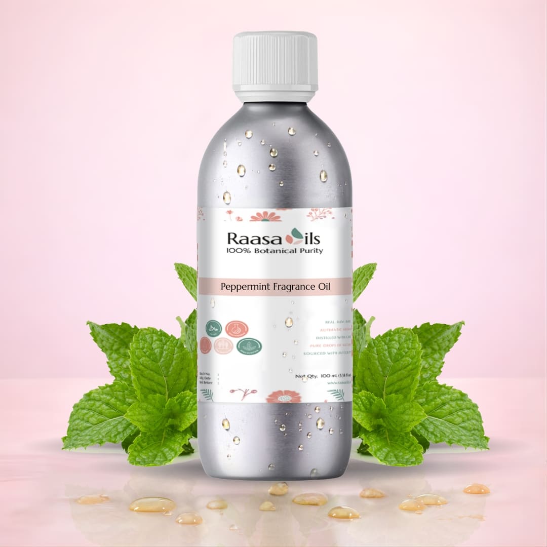 Bottle of Raasa Oils Peppermint Fragrance Oil with peppermint leaves on a pink background