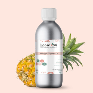 Bottle of Raasa Oils pineapple fragrance oil with a pineapple and leaves on a light pink background