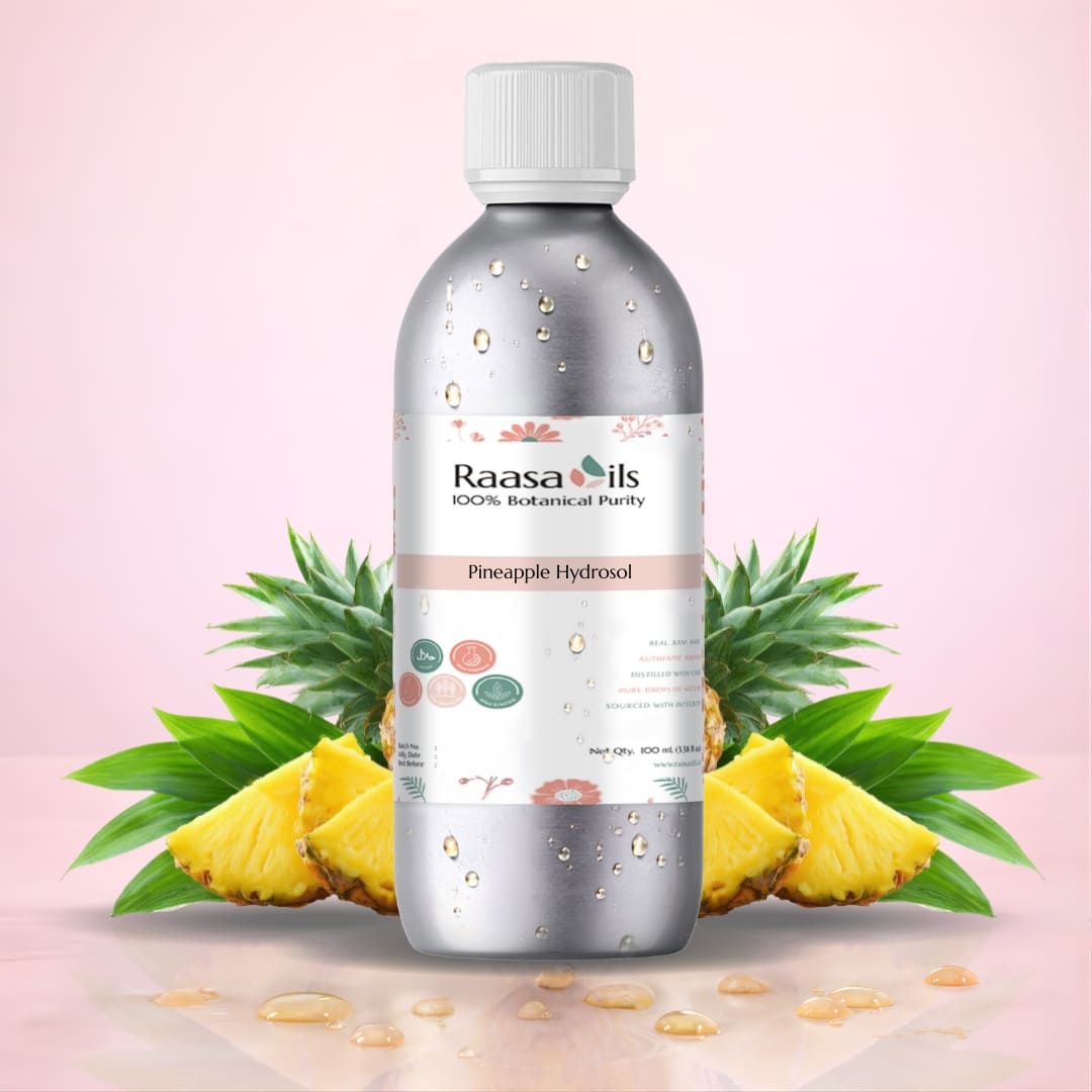 Bottle of Raasa Oils Pineapple Hydrosol with pineapple slices and leaves on a pink background