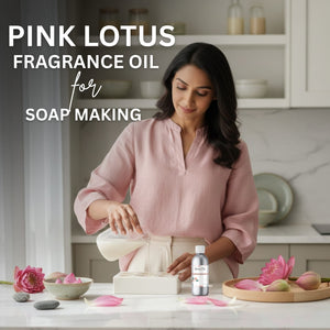 Woman in a kitchen with pink lotus flowers and a bottle of Pink Lotus fragrance oil for soap making.