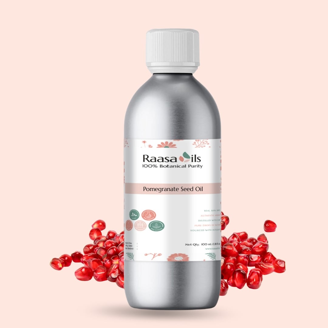 Bottle of Raasa Oils pomegranate seed oil with pomegranate seeds on a beige background