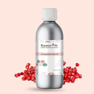 Bottle of Raasa Oils pomegranate seed oil with pomegranate seeds on a beige background