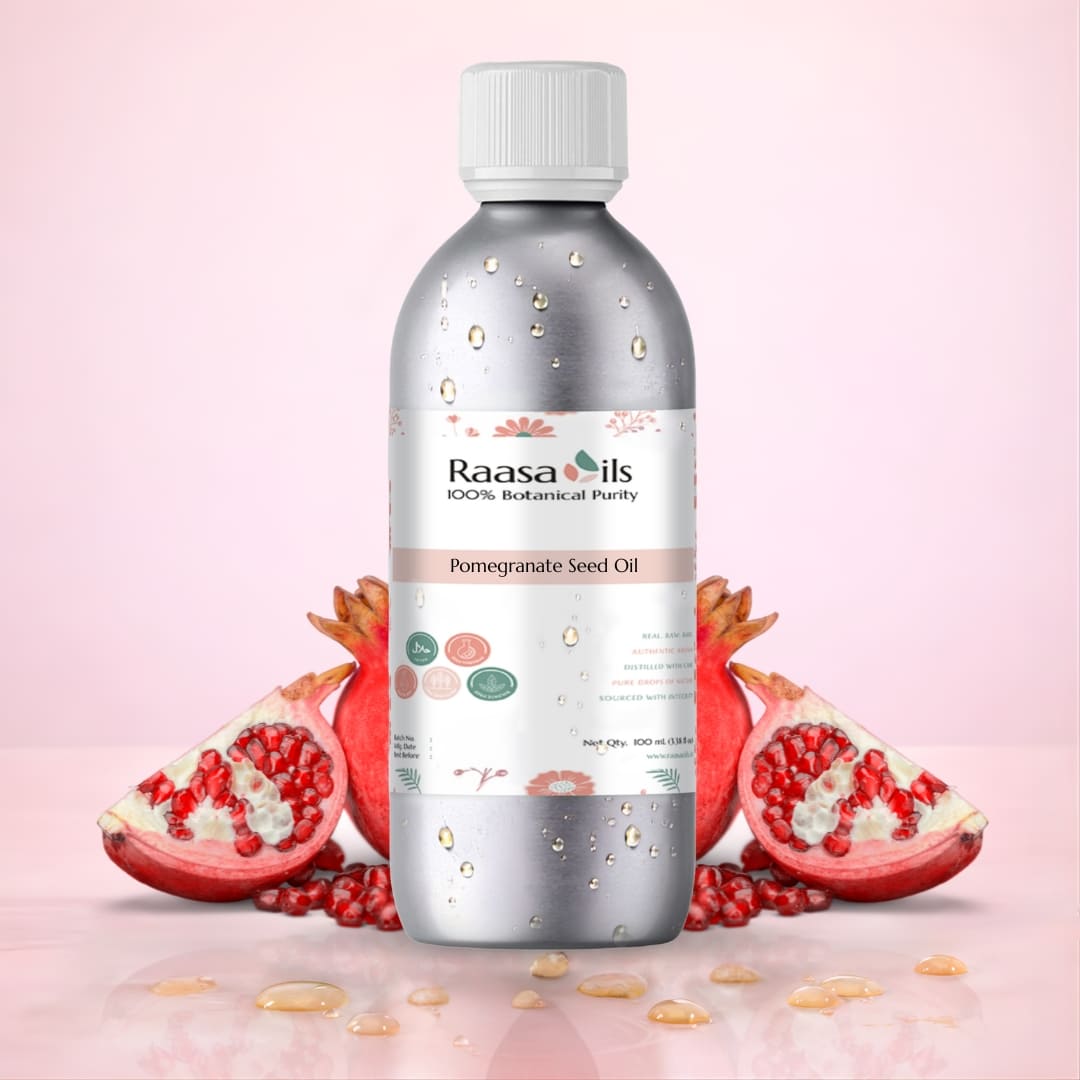 Bottle of Raasa Oils Pomegranate Seed Oil with pomegranates on a pink background