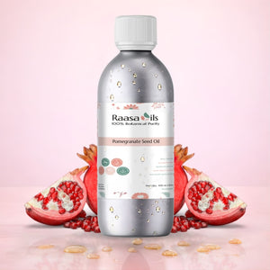 Bottle of Raasa Oils Pomegranate Seed Oil with pomegranates on a pink background